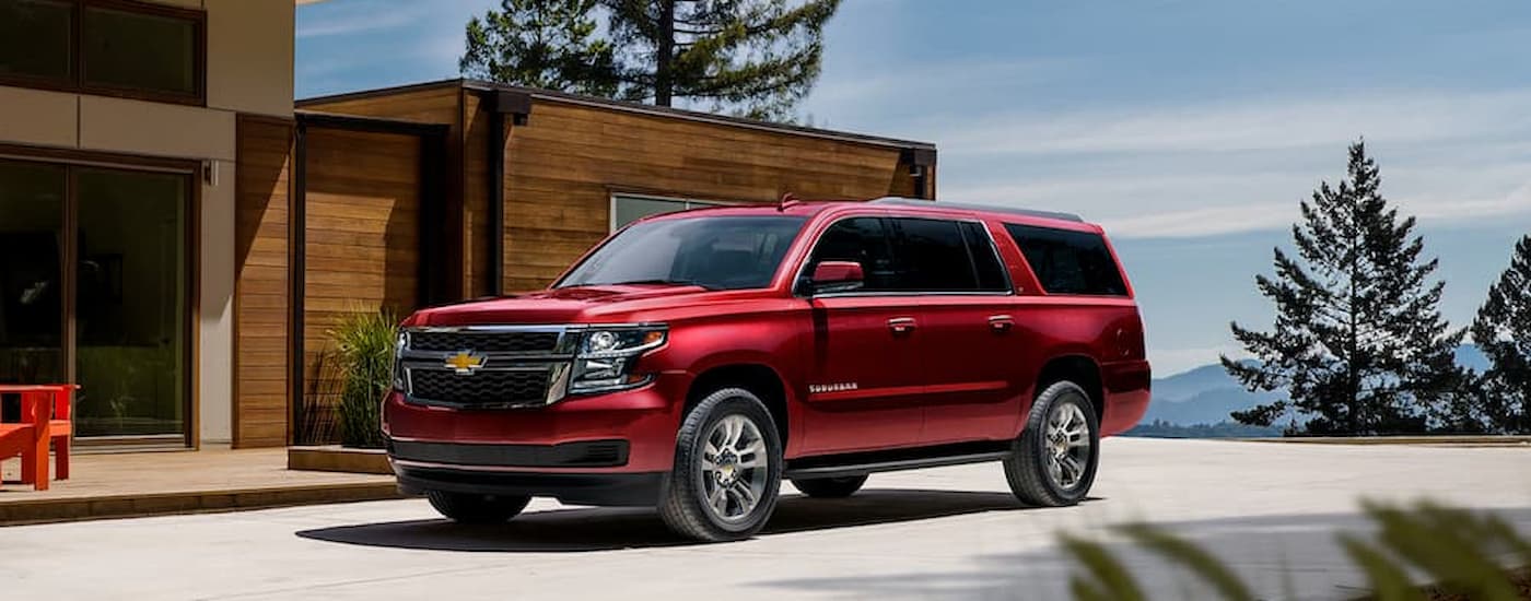 A red 2020 Chevy Suburban is shown parked in a driveway after leaving a used car dealer near Indianapolis.