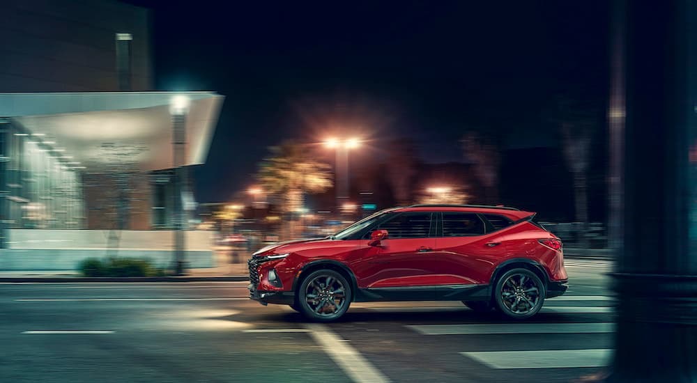 A red 2019 Chevy Blazer is shown from the side on a city street after leaving a used Chevy dealer.