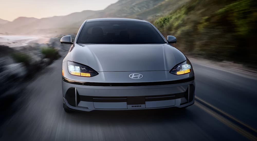 A silver 2023 Hyundai Ioniq 6 driving on an open road after viewing electric cars for sale.
