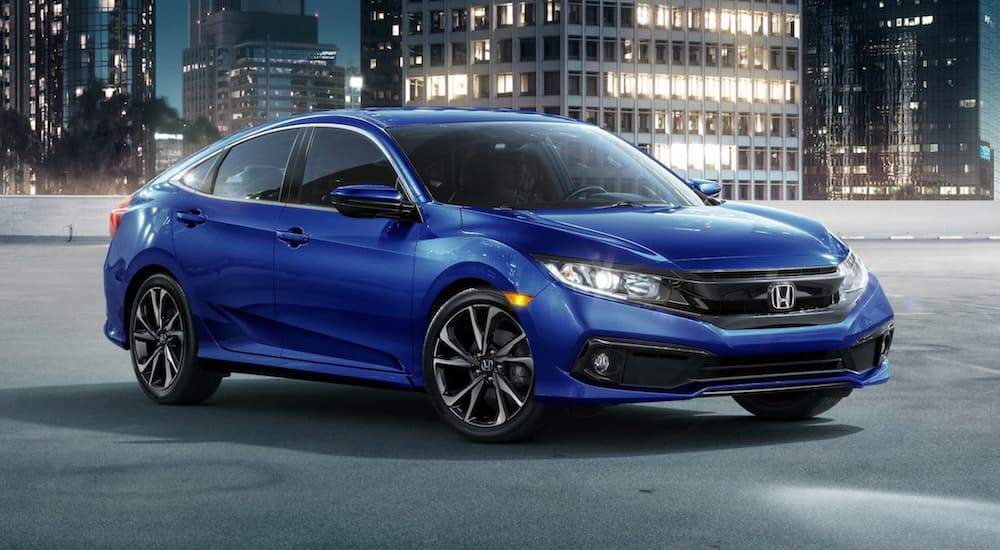 A blue 2020 Honda Civic Sport, one of many used cars for sale near Columbus, in a city at night.