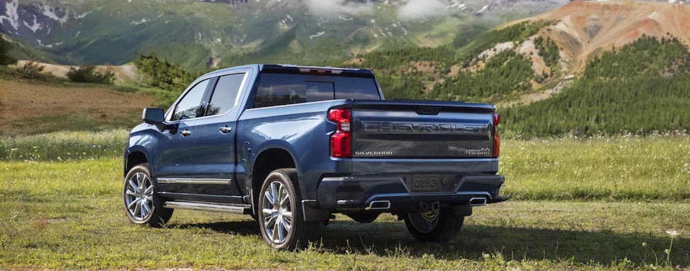 A blue 2022 Chevy Silverado 1500 High Country is shown from the rear at an angle.