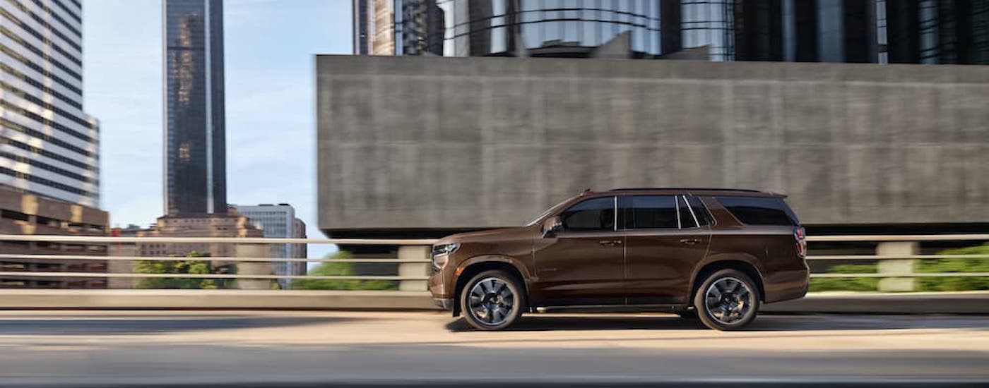 A brown 2022 Chevy Tahoe RST is shown from the side on a freeway.