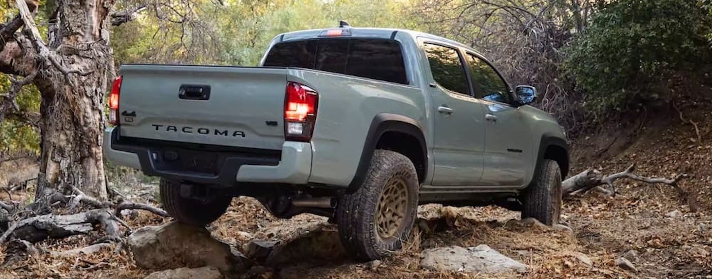 A grey 2022 Toyota Tacoma Trail is shown from the rear at an angle while off-road.