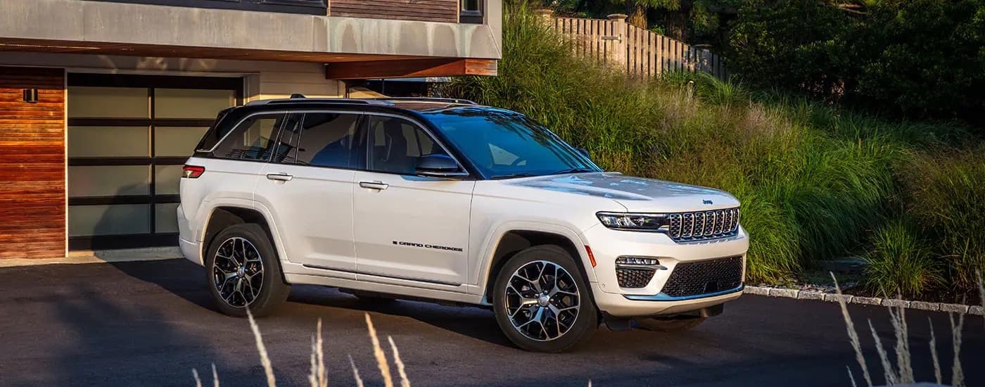 A white 2023 Jeep Grand Cherokee is shown from the front at an angle after leaving a dealer that has used SUVs for sale near Mooresville.