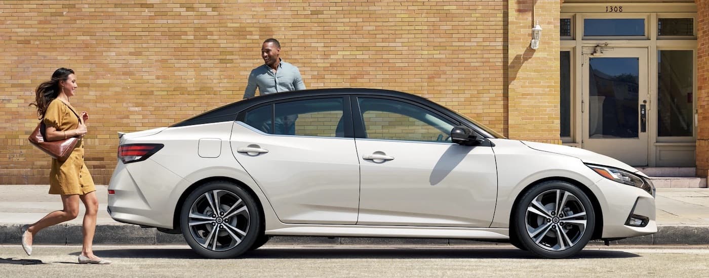 A white 2023 Nissan Sentra SR is shown from the side on a city street after leaving a dealer that has used cars for sale near Columbus.