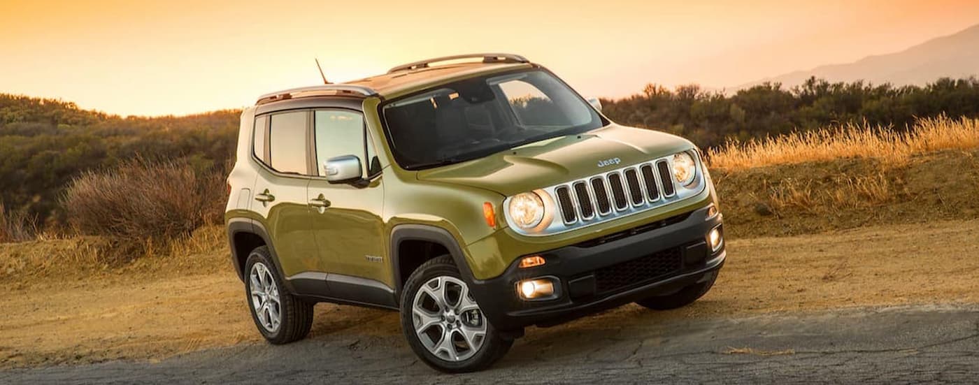 A green 2015 Jeep Renegade is shown parked on the side of a road in a dirt area.