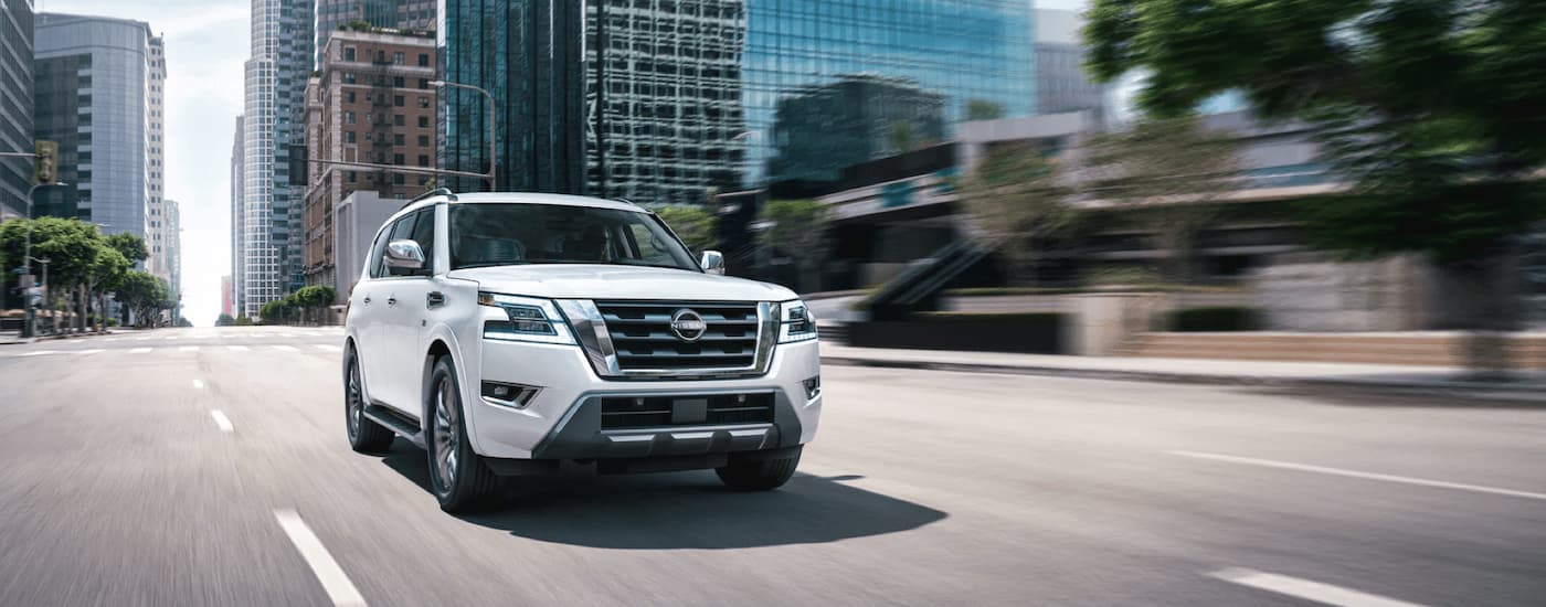 A white 2022 Nissan Armada is shown driving on a city street.