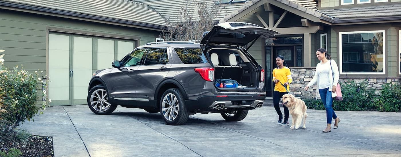 A family is shown putting supplies into the back of a silver 2021 Ford Explorer.