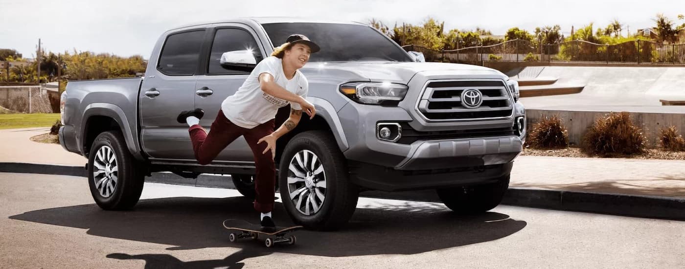 A silver 2022 Toyota Tacoma is shown parked near a skate park after viewing used trucks for sale.