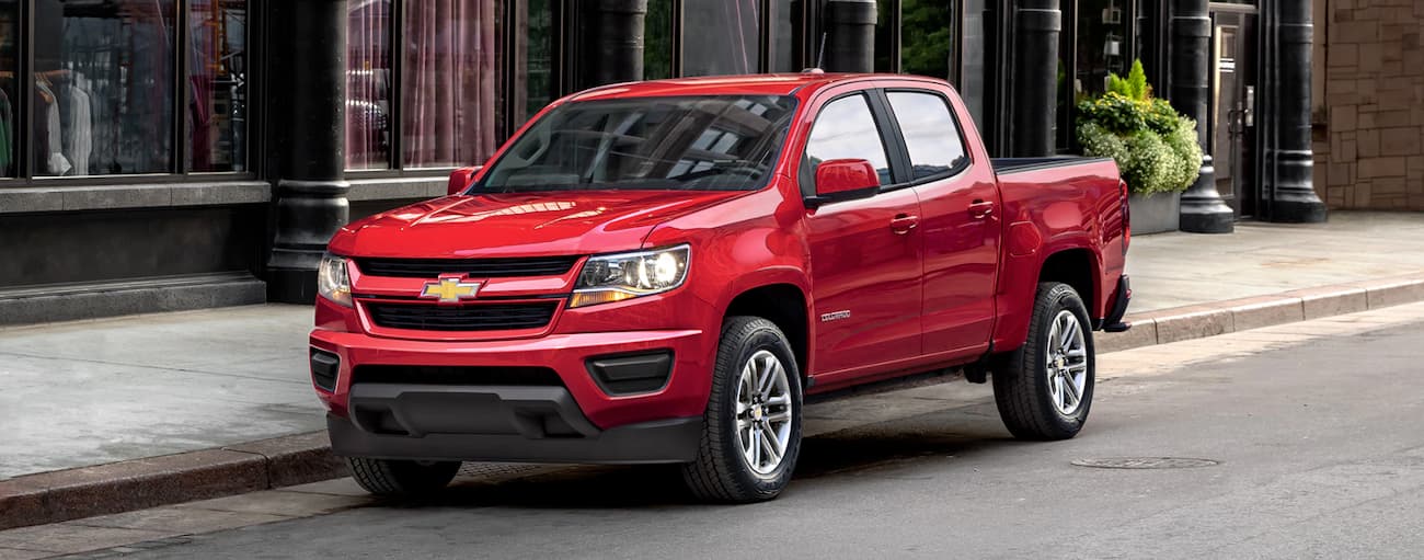 A red 2019 Chevy Colorado is shown parked on the side of a city street.