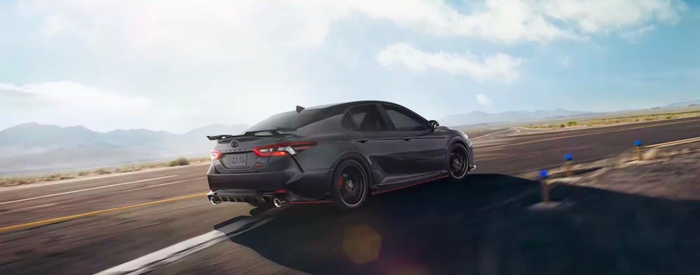 A black 2023 Toyota Camry TRD is shown from the rear at an angle.