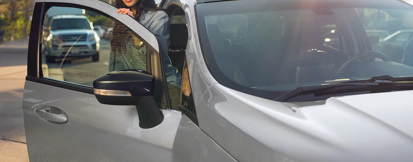 A person is shown getting out of a the passenger side of a silver 2022 Ford EcoSport.